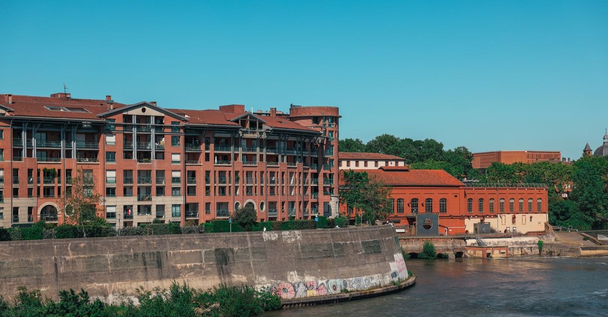 A picturesque view of brick buildings along the river in Toulouse, Occitanie, France.