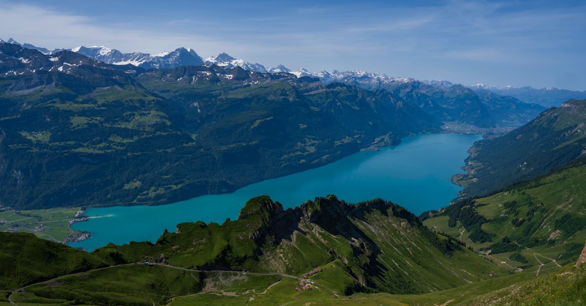 Interlaken Travel Guide for July 2026: Mountains, Passes, and Booking Strategy A breathtaking aerial view of Lake Brienz surrounded by the stunning Swiss Alps in summer.