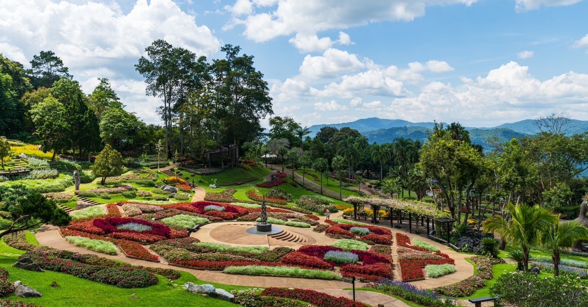 SuanTung Coffee & Guesthouse in Chiang Rai: A Quiet Stop on Suan Tung Road Stunning landscaped garden at Doi Tung Royal Villa, Chiang Rai, Thailand, surrounded by lush greenery and mountains.