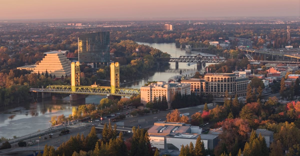Stunning aerial shot of Sacramento, California at sunset showcasing iconic landmarks and the Sacramento River.
