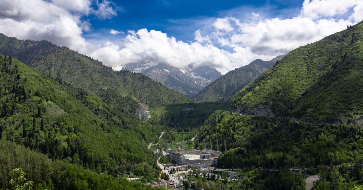 Amigo Hostel in Almaty: A Quiet Four-Floor Stay Near Subway and City Sights A breathtaking aerial view of Almaty, Kazakhstan, showcasing lush green mountains and a sprawling valley.