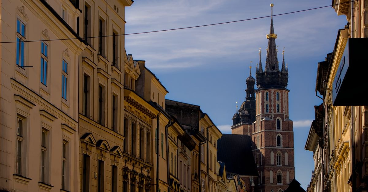 View of St. Mary's Basilica along a historic street in Kraków, showcasing medieval architecture.