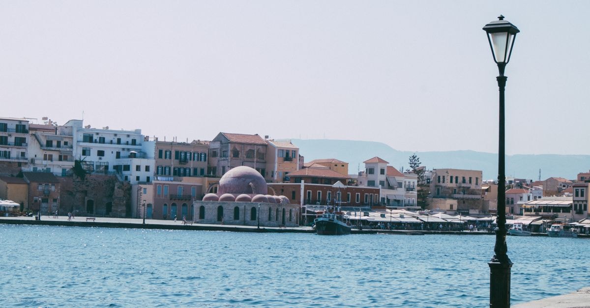 Mosaic Urban Rooms in Chania: A Renovated Pre-WWII Townhouse Stay Beautiful waterfront view of Chania with historic architecture and blue sea.