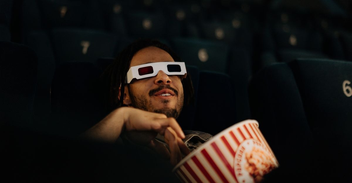 Spider-Man: Brand New Day 創下北美 1.68 億美元首日票房紀錄 一名男子戴著 3D 眼鏡在電影院裡一邊看電影一邊享用爆米花。