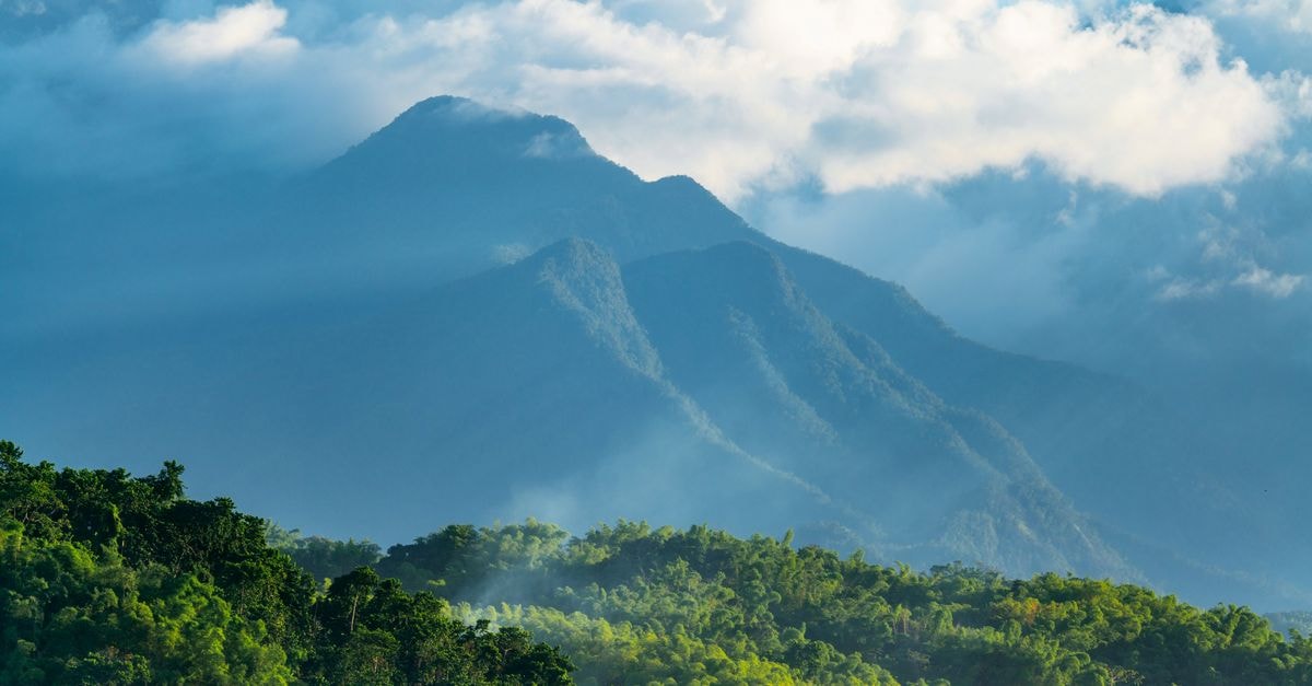 Serene view of the Blue Mountains in Jamaica, shrouded in clouds and sunlight.