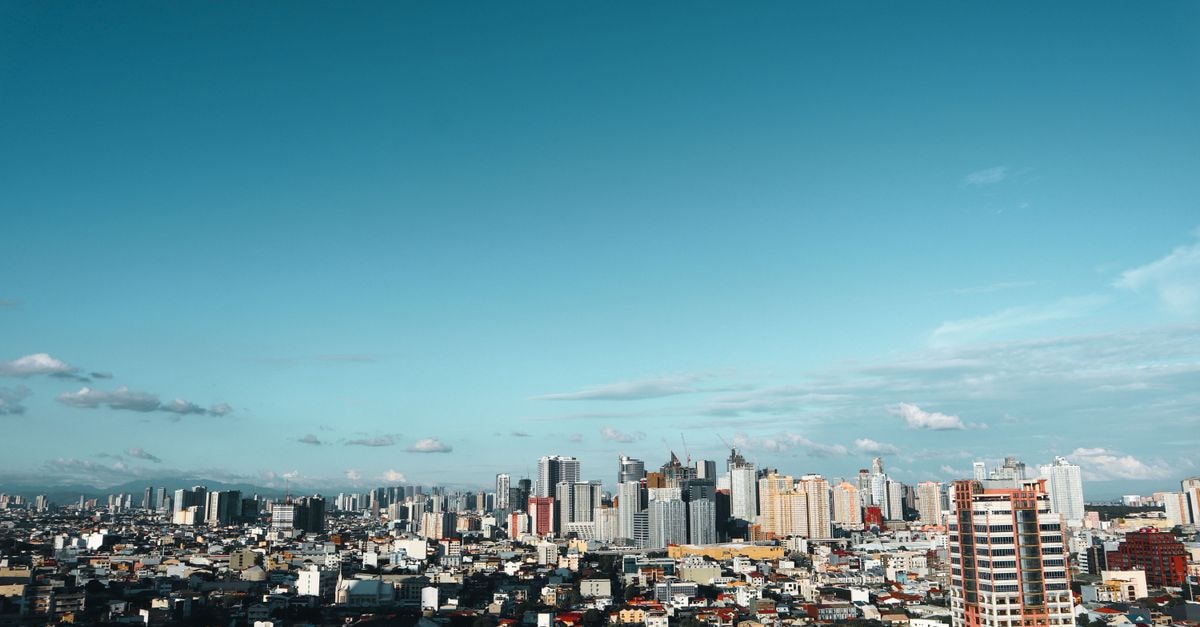 OYO 431 Apollo 11 Apartelle in Pasay: Budget Stay Near SM Mall of Asia Stunning view of the Manila cityscape with modern skyscrapers under a clear blue sky.