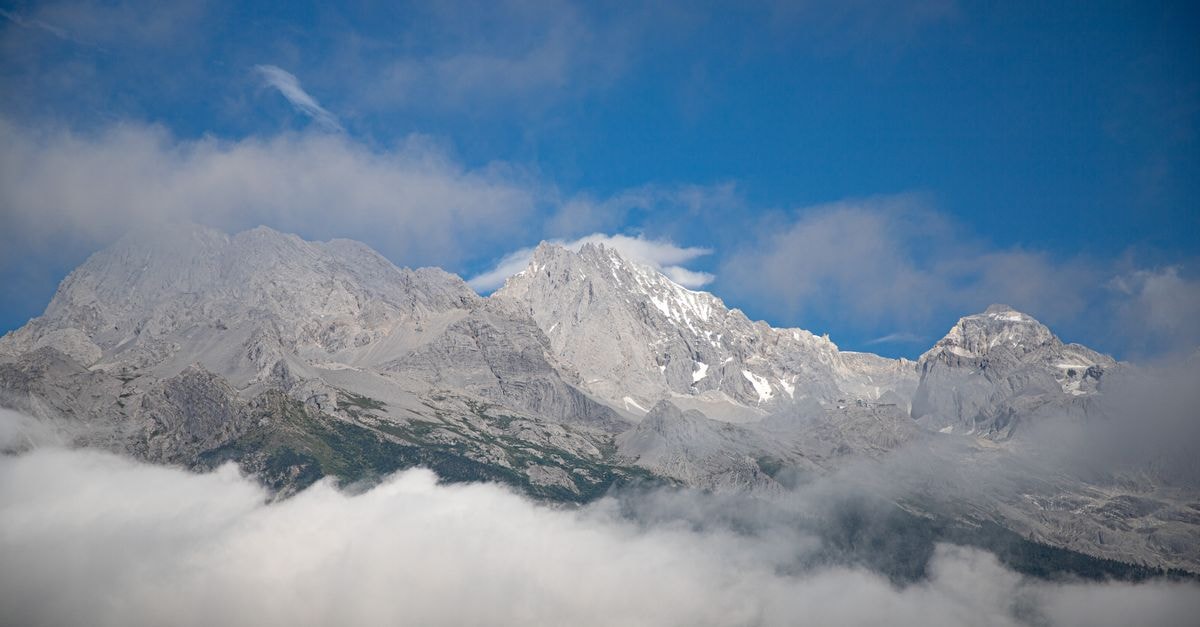 International Youth Hostel Lijiang in Lijiang: A Naxi-Style Base Inside the Old Town Stunning view of Jade Dragon Snow Mountain with clouds and blue sky in Lijiang, China.