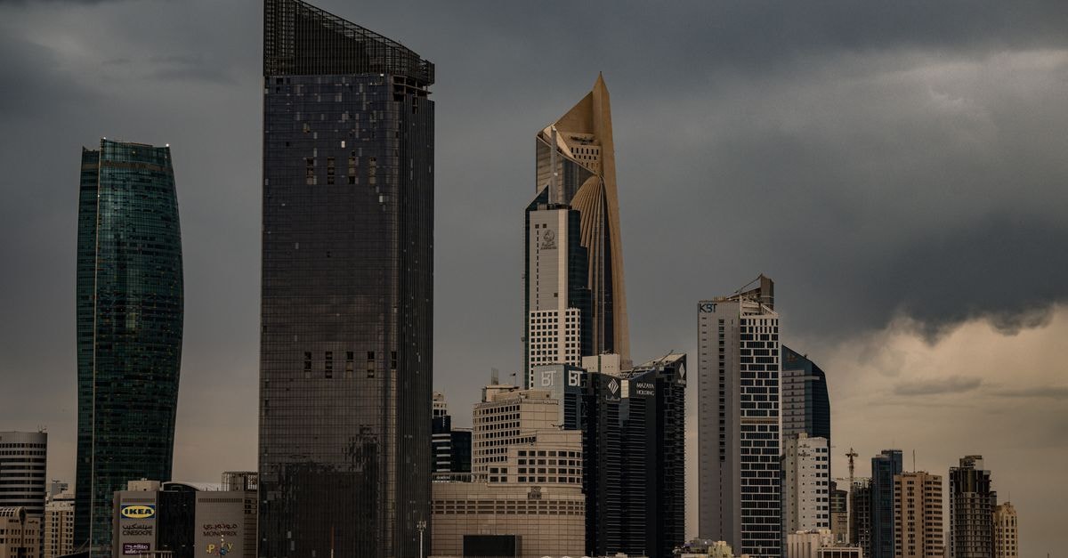 Marriott Executive Apartments in Kuwait City: Apartment-Style Living Debuts A moody Kuwait City skyline with towering skyscrapers under a cloudy sky.