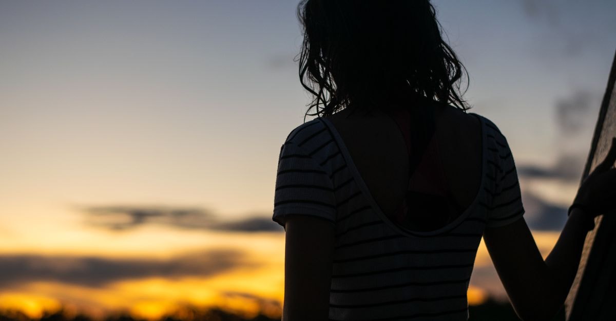 Hotel Acosta in Iquitos: A Central Stay Steps from Plaza de Armas Silhouette of a woman viewing the sunset in Iquitos, Peru, offering a serene and reflective scene.