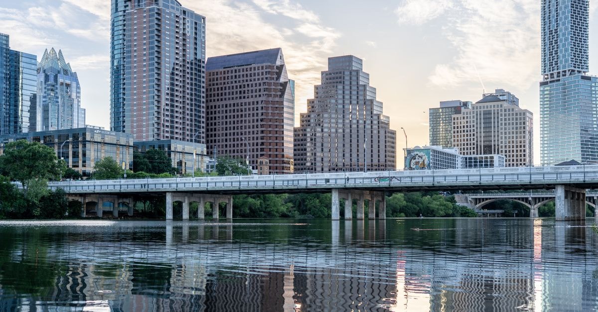 Beautiful view of Austin's skyline with reflections in Lady Bird Lake during daytime.