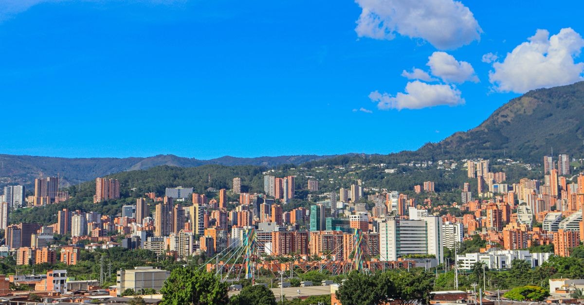 Medellín travel guide: weather, getting around, and food culture A stunning view of Medellín, Colombia with a backdrop of mountains and clear blue skies.