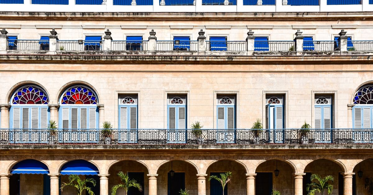 Detailed view of colonial architecture with blue shutters and arches in Havana, Cuba.