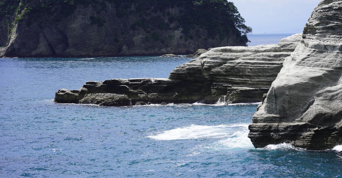 Beautiful rocky cliffs and blue ocean in Nishiizu, Shizuoka, Japan, under a clear sky.