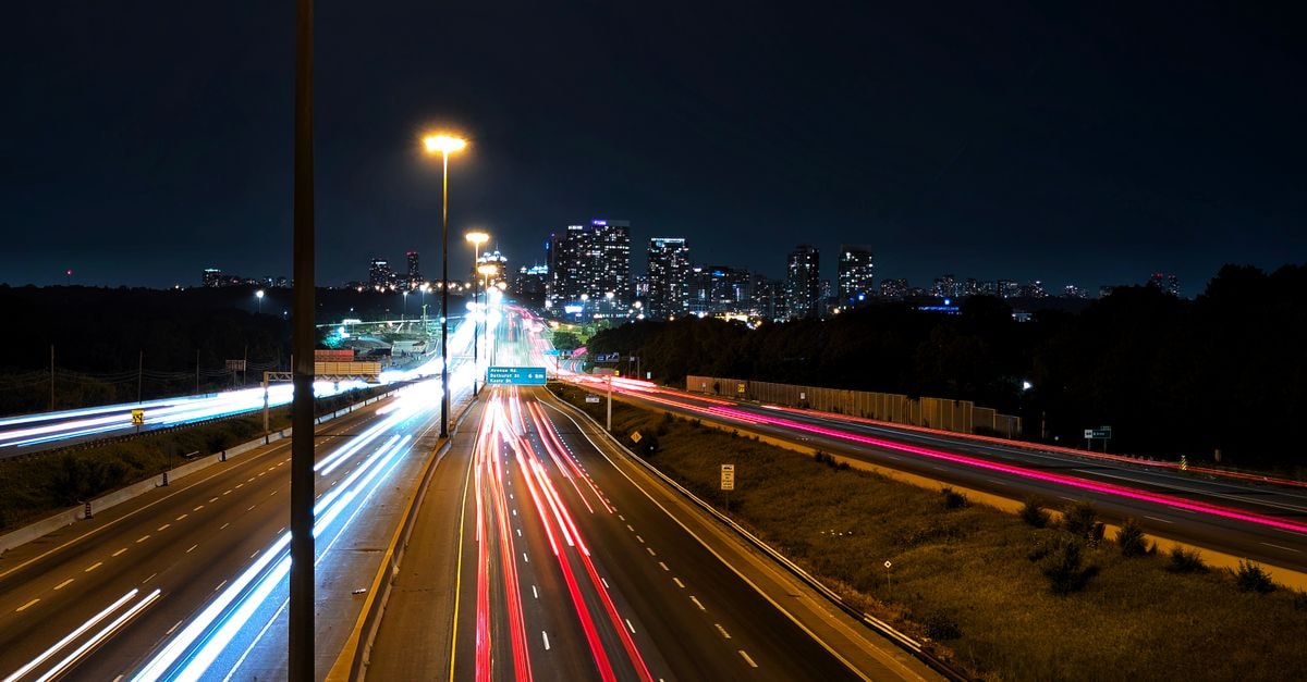 Staybridge Suites Toronto - Vaughan South: Suite-Style Stays on Steeles Avenue Long exposure capturing vibrant light trails on Toronto highway with city skyline at night.