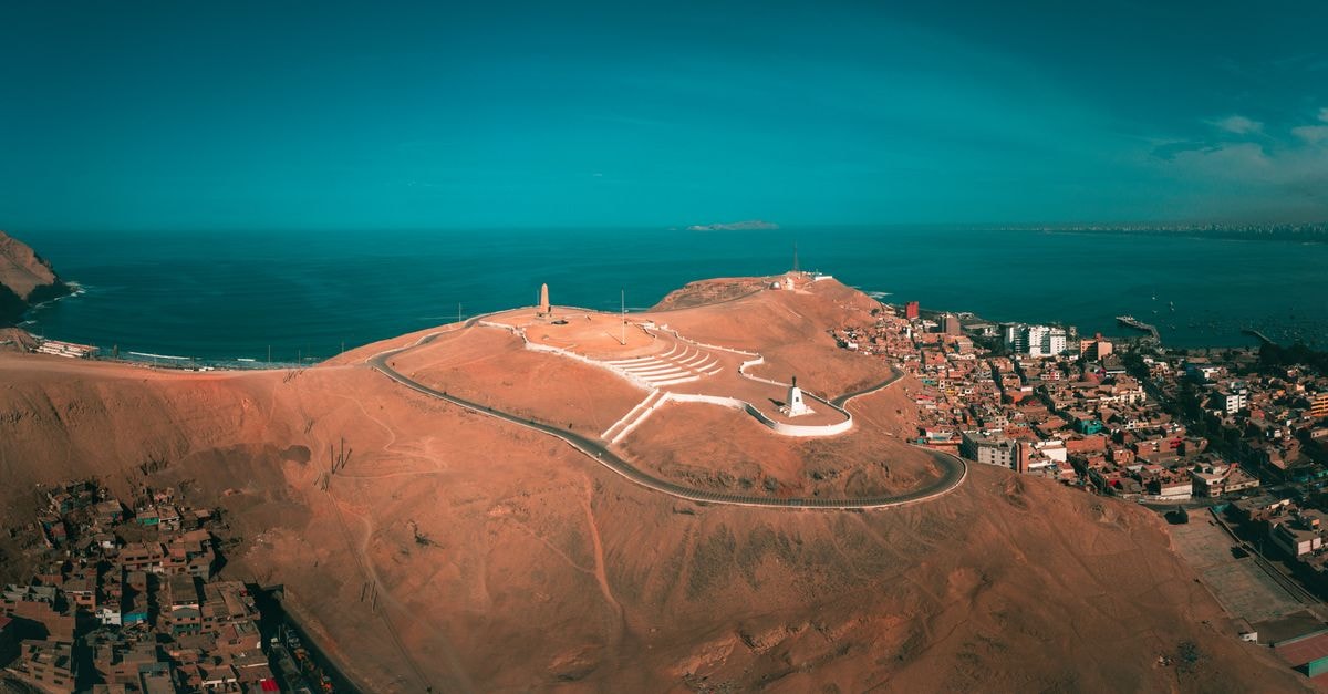 A stunning aerial view of Callao, Peru featuring coastal landscapes, hills, and ocean horizon.