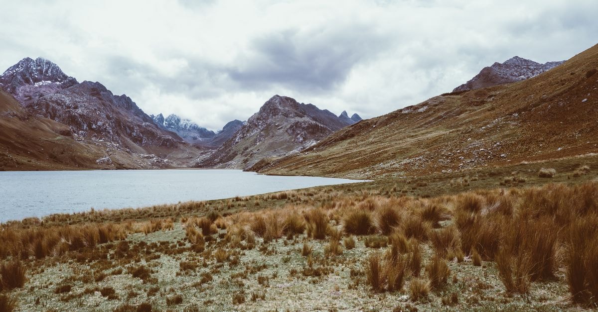 Huaraz Travel Guide: Andean Gateway to Big Skies Breathtaking landscape of a serene lake surrounded by the majestic Peruvian Andes in Huaraz.