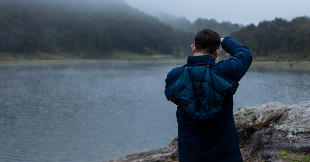 Villa Shalom in Santa Rosa de Copán: A Relaxation Retreat A man in a jacket stands by a foggy lakeshore in Santa Rosa de Lima, Mexico.