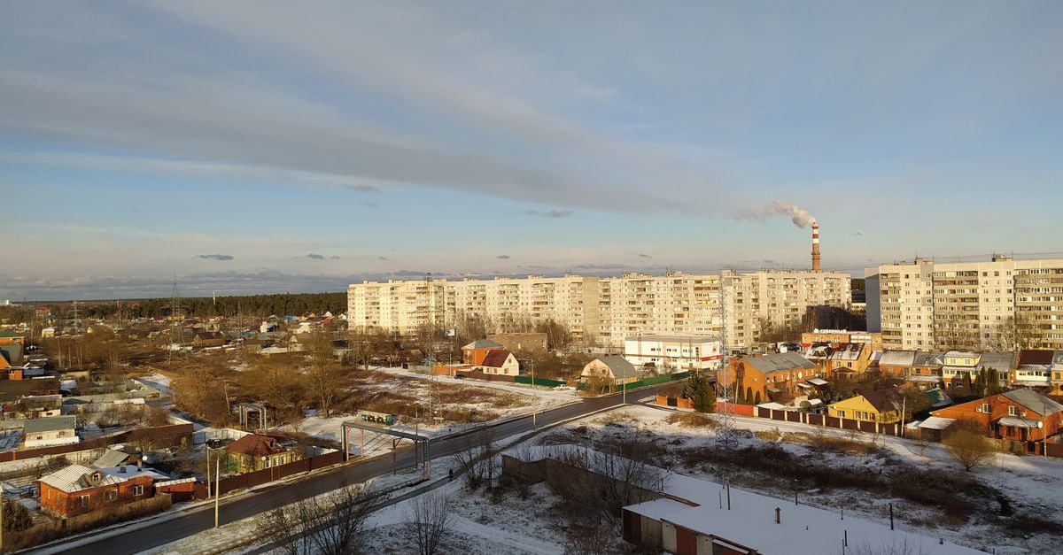 Aerial shot of a snow-covered urban area with high-rise apartments and clear skies.