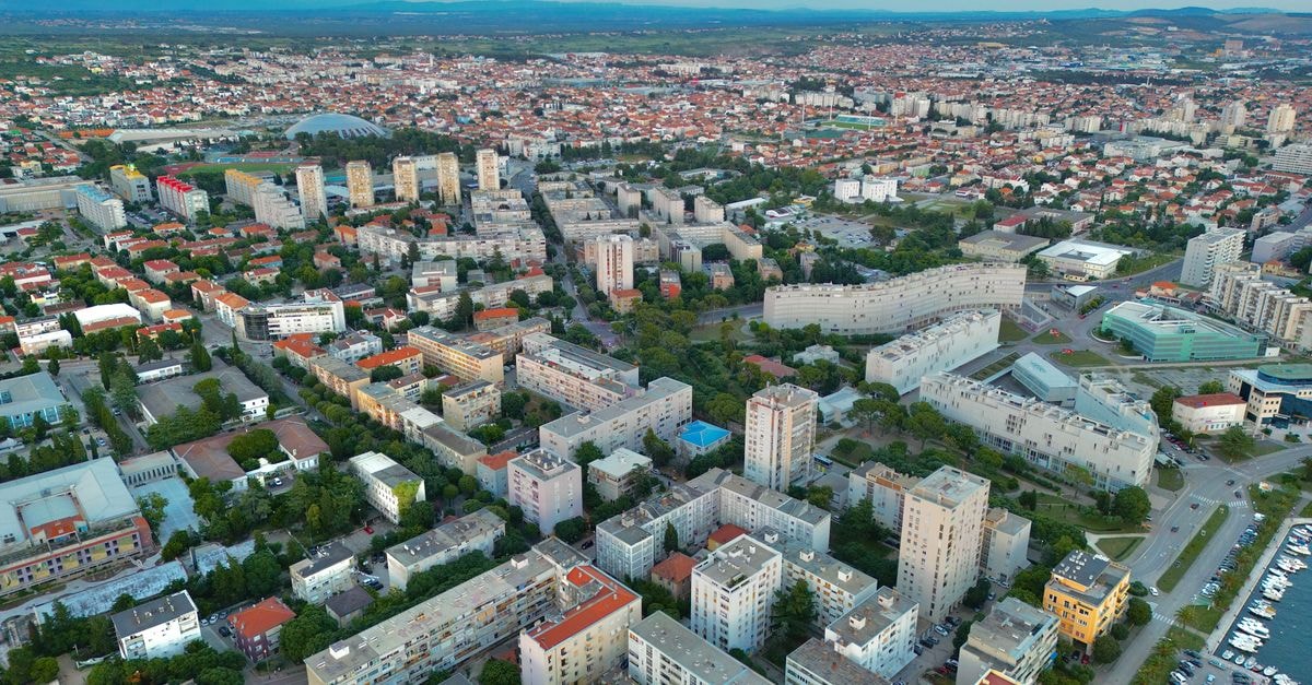 Prenočišča Mraz in Velenje: Forest-Edge Stay on Lipa 54 Aerial view of Zadar, Croatia, showcasing diverse architecture and vibrant city life under a serene sky.