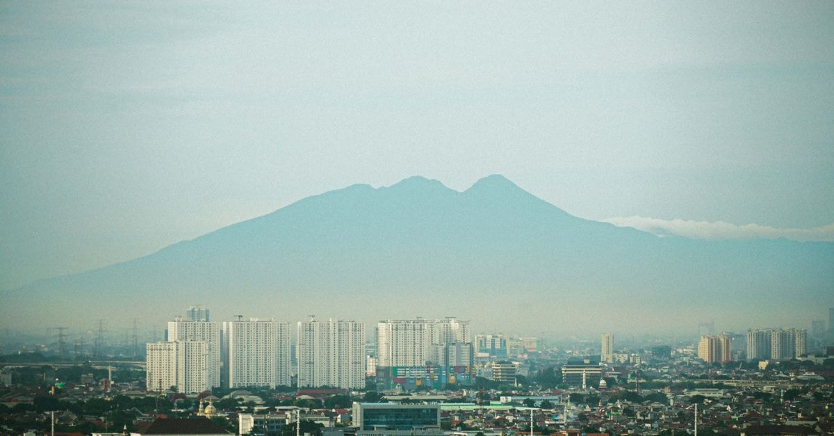 Hotel Metland in Cirebon: A Central Stay Near the Railway Station Distant view of Jakarta's cityscape with Mount Salak looming majestically under a clear sky.