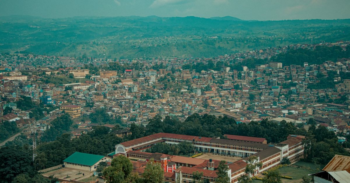 Aerial shot of Bukavu cityscape against lush hills, showcasing urban architecture and natural landscape.