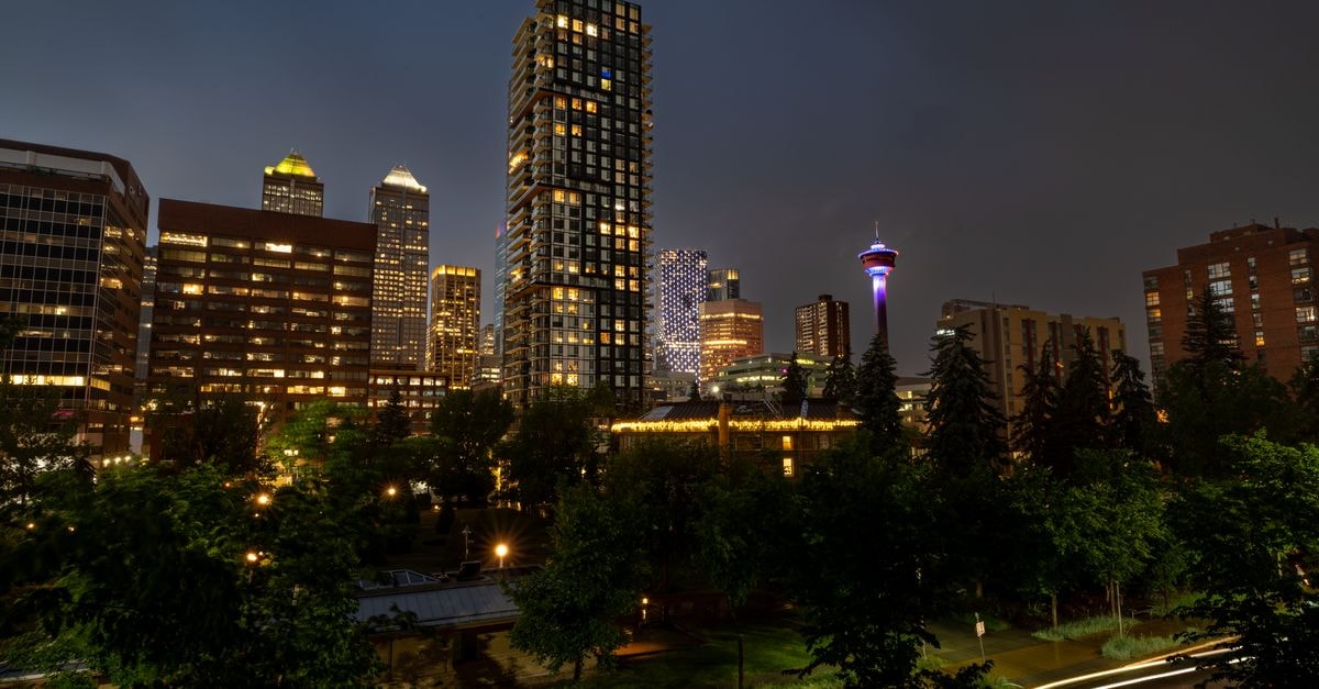 Sheraton Suites Calgary Eau Claire, Calgary — Riverfront Suites in Downtown Eau Claire Stunning night view of Calgary's modern skyline featuring the illuminated Calgary Tower and skyscrapers.