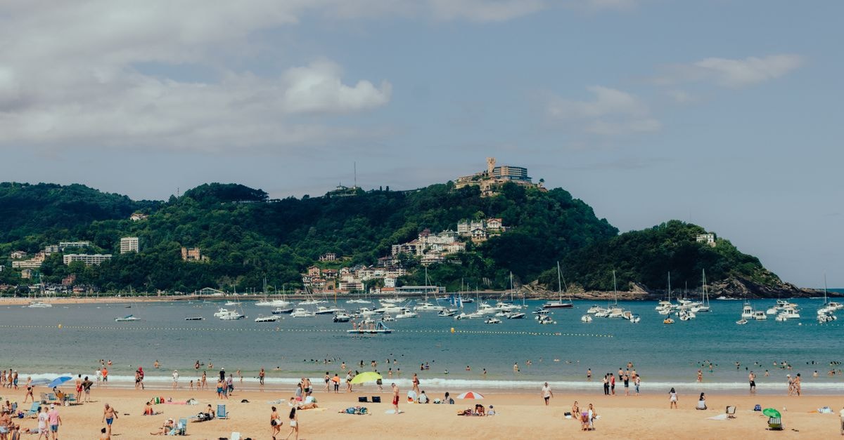 Crowded La Concha Beach in San Sebastián with scenic views and vibrant atmosphere.