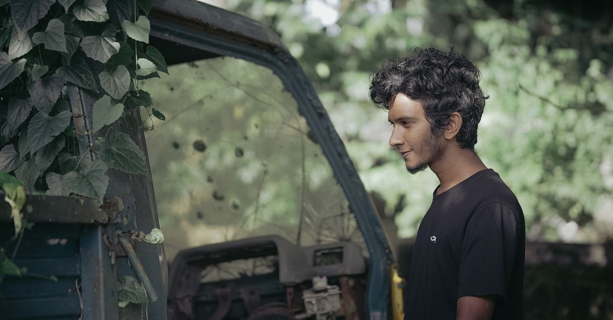 IASO Bio completes acquisition of MediSix to extend CAR-T into T-cell malignancies A man stands beside an abandoned vehicle overgrown with leaves, capturing a rustic outdoor scene.