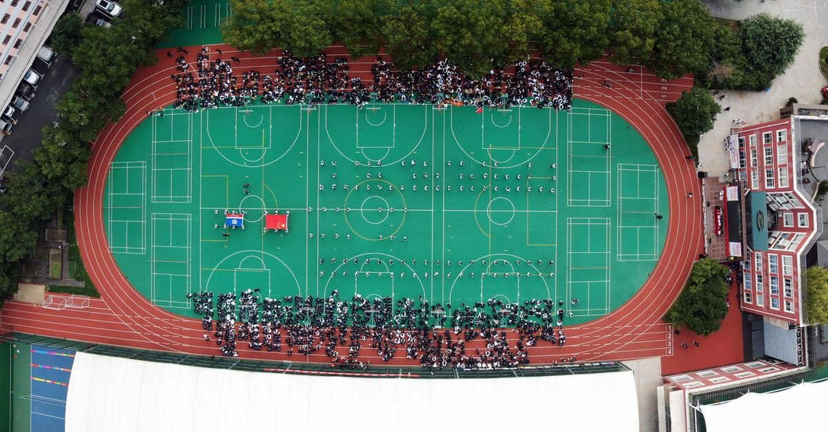 Manush Shah and Diya Chitale clinch mixed doubles bronze at 2026 Asian Games after semifinal loss to China Aerial view of a sports complex in Shanghai with people gathered on a green field.