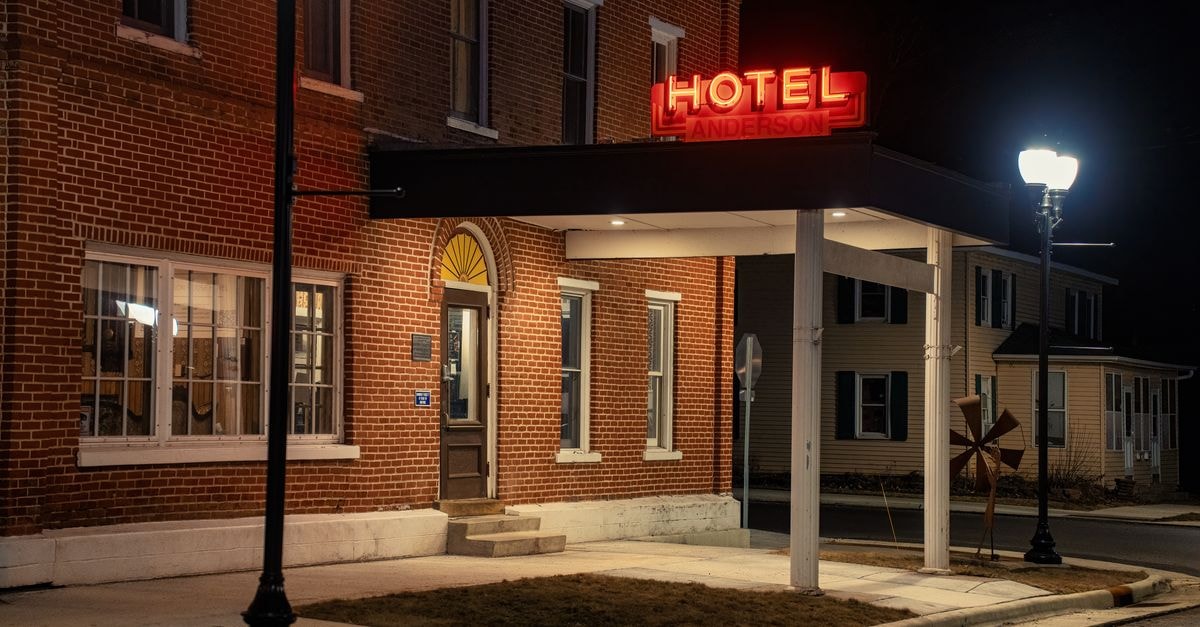 Things to do in Augusta, Maine: a quiet capital worth slowing down for Brick exterior of Anderson Hotel in Wabasha, MN at night with illuminated signage.