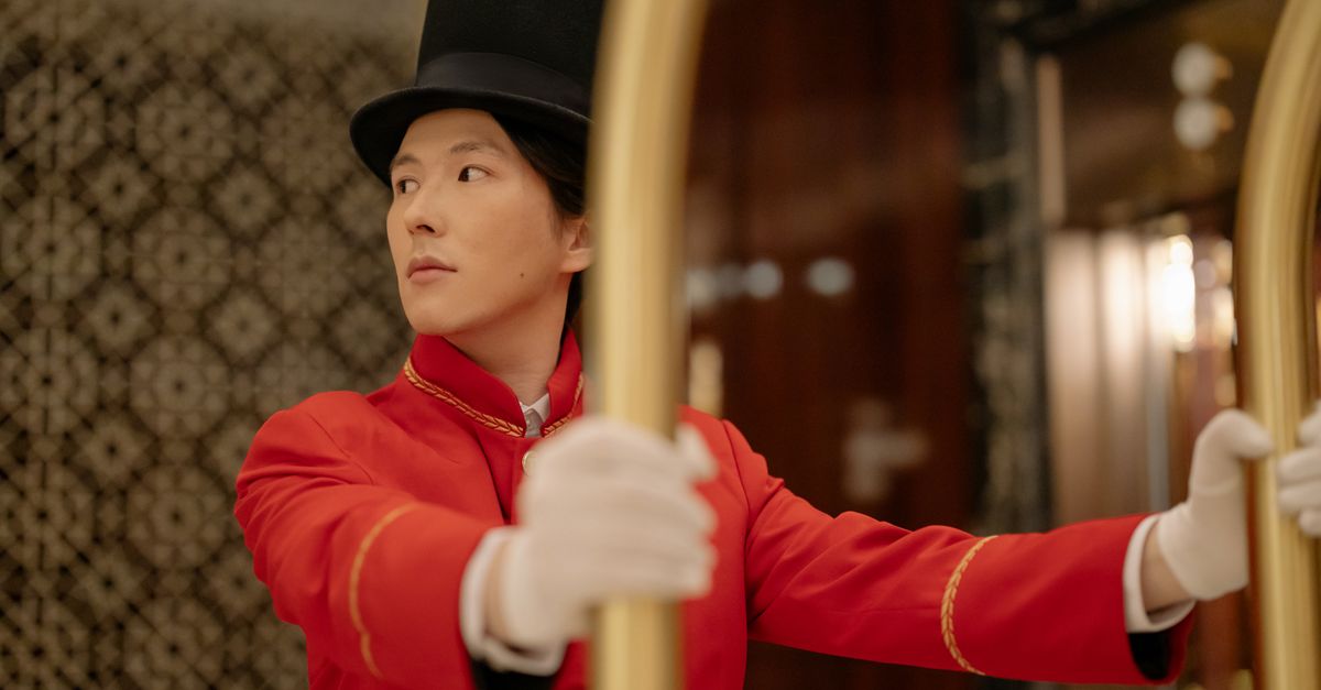 Netflix Charts Theatrical Run for Lee Chang-dong's 'Possible Love,' Confirms Awards Push An attentive bellboy in a classic red uniform assists guests by pushing a luggage cart in a hotel lobby.
