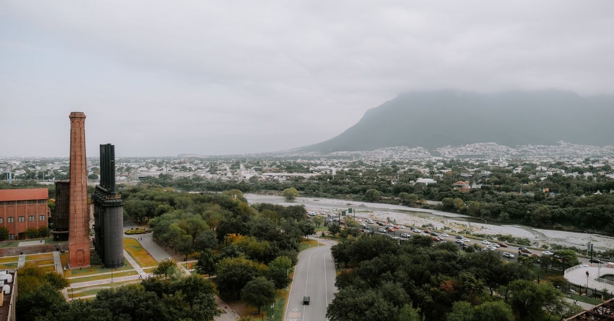 Scenic aerial view of Monterrey, Mexico, showcasing an industrial skyline and lush greenery.