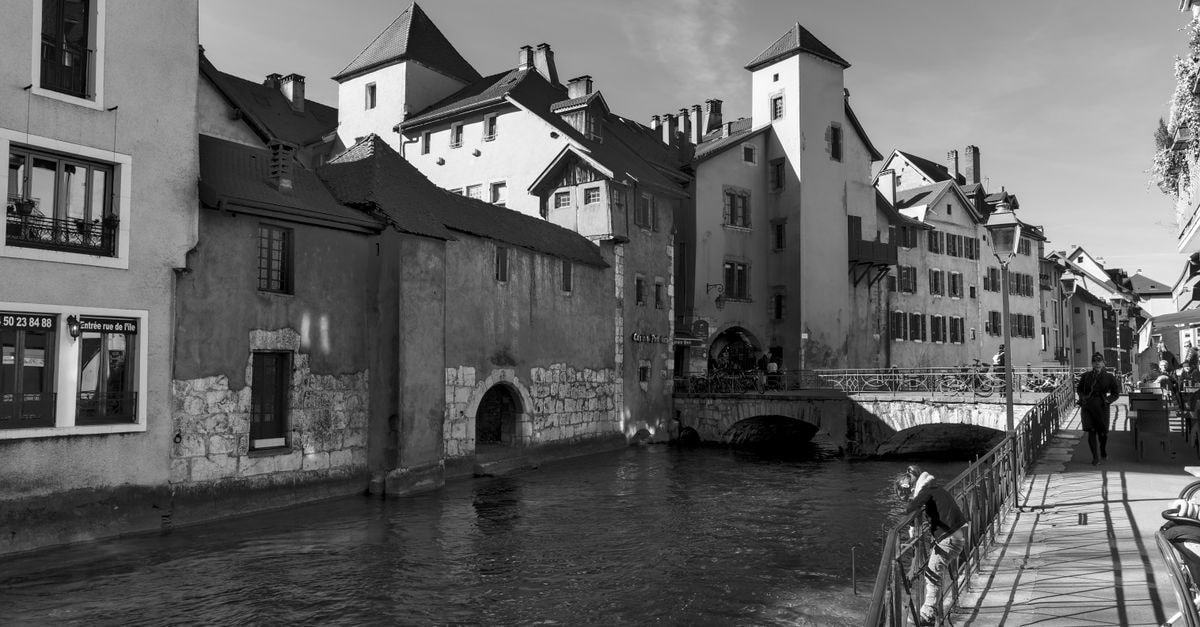 Novotel Annecy Centre in Annecy: A 5-Minute Walk to Lake and Old Town Black and white view of a picturesque canal in Annecy's old town with historic buildings.