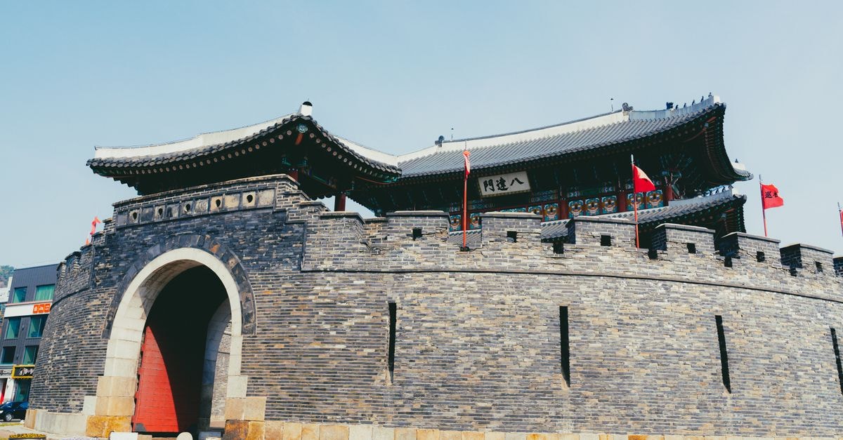 Hwaseong-si Travel Guide: Things to Do and Getting Around Vivid view of the Hwaseong Fortress in Suwon, showcasing traditional Korean architecture under a bright sky.