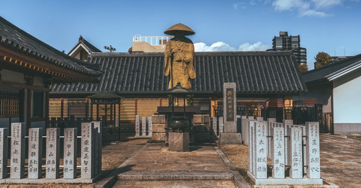 Explore the serene Shitennoji Temple courtyard in Osaka under a clear blue sky.