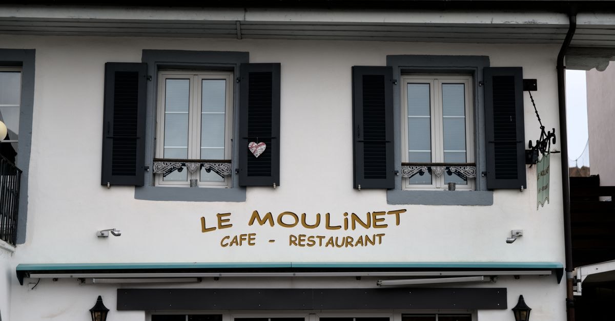 Hôtel Alpes et Lac, Neuchâtel — A Station-Front Stay with Lake-and-Alps Views Elegant exterior of Le Moulinet Cafe-Restaurant showcasing traditional Swiss architecture.