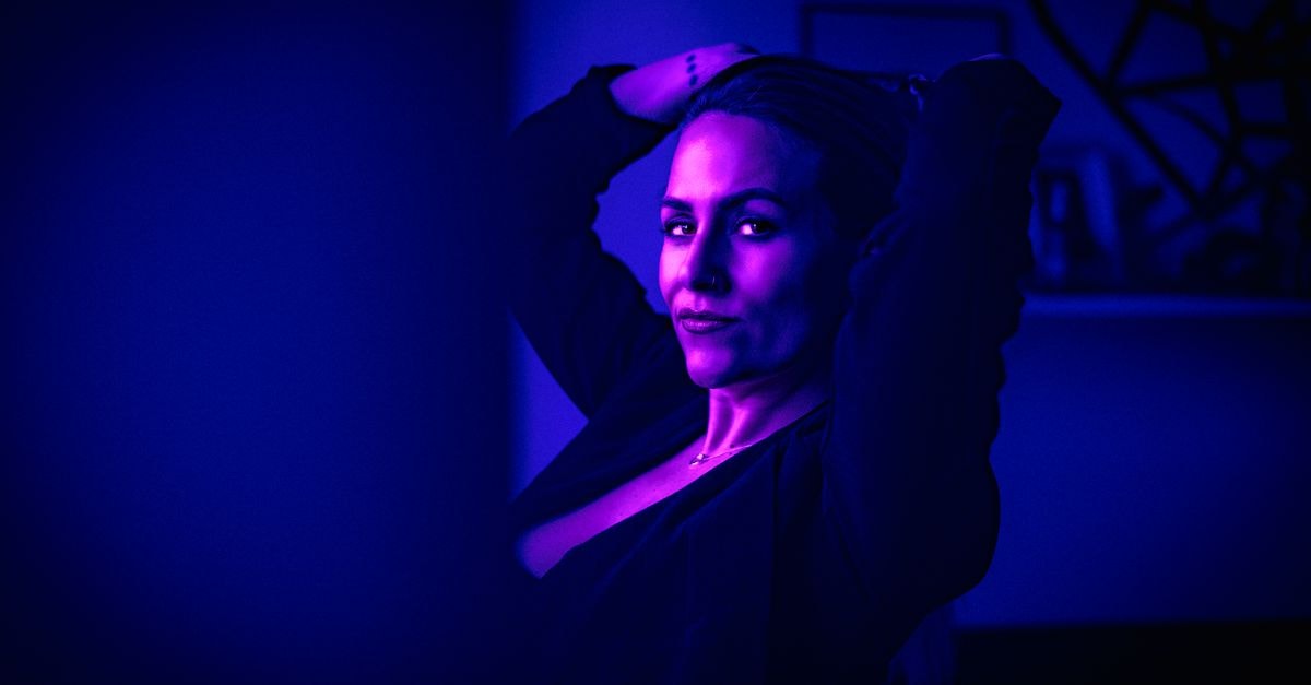 A captivating cyberpunk-themed portrait of a woman lit with neon purple lighting.