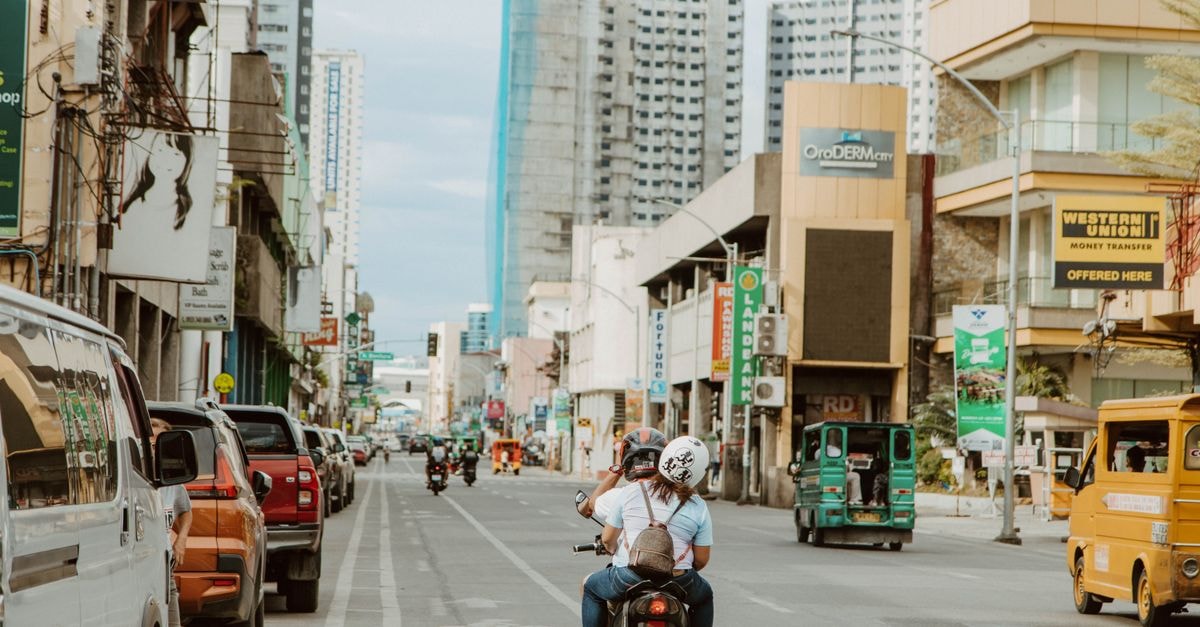 The Pinnacle Hotel and Suites, Davao City — Nine Halls, One Stay Bustling street scene in Davao City with motorcycles, jeepneys, and urban architecture.
