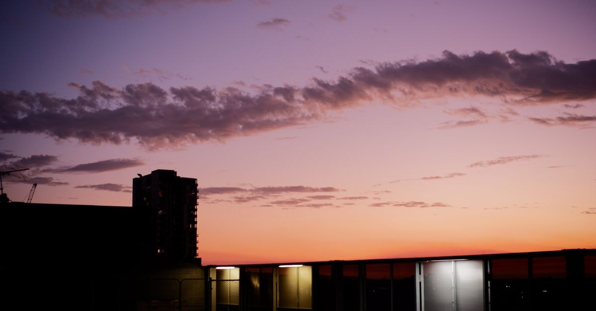 Peppers Waymouth Adelaide: City‑Centre Stay with Marble Bathrooms Silhouette of city buildings against a vibrant sunset sky in Adelaide, Australia.