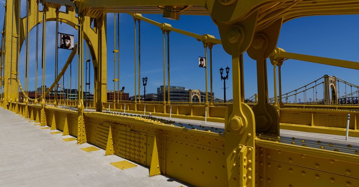 DoubleTree by Hilton Hotel & Suites Pittsburgh Downtown — Bigelow Square, Downtown Steps to PPG Paints Arena Vibrant yellow suspension bridge standing out against a clear blue sky, showcasing modern engineering.