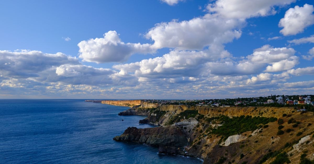 Smile Hostel Sevastopol: Central Hill Budget Stay on Bolshaya Morskaya Stunning view of Sevastopol coastline with azure sea and dramatic clouds.