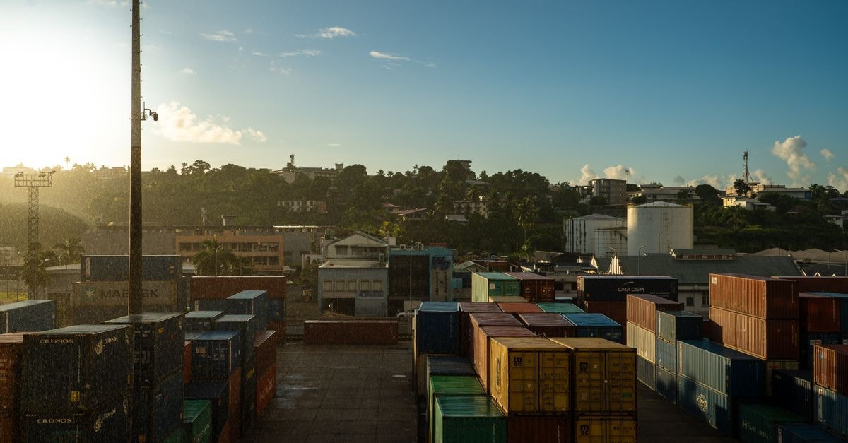 Holiday Inn Suva, Fiji — Harbour Views from Victoria Parade Shipping containers at Suva port in Fiji with sunrise, showcasing a vibrant industrial landscape.