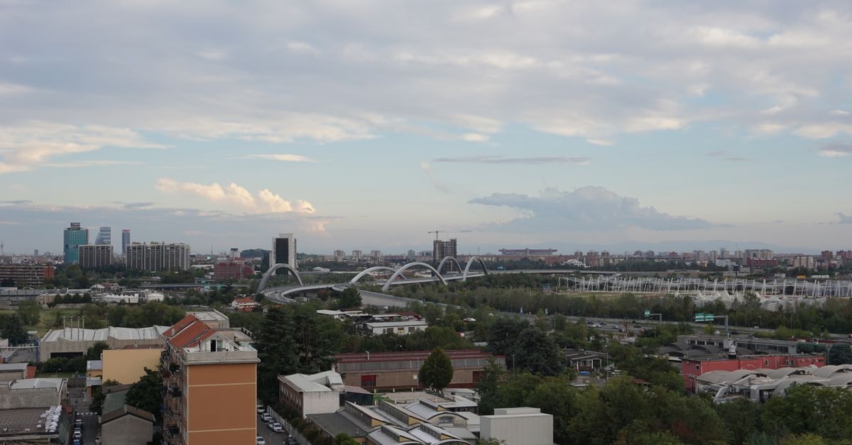 Explore the vibrant urban skyline of Milan with a view of modern architecture and lush greenery.