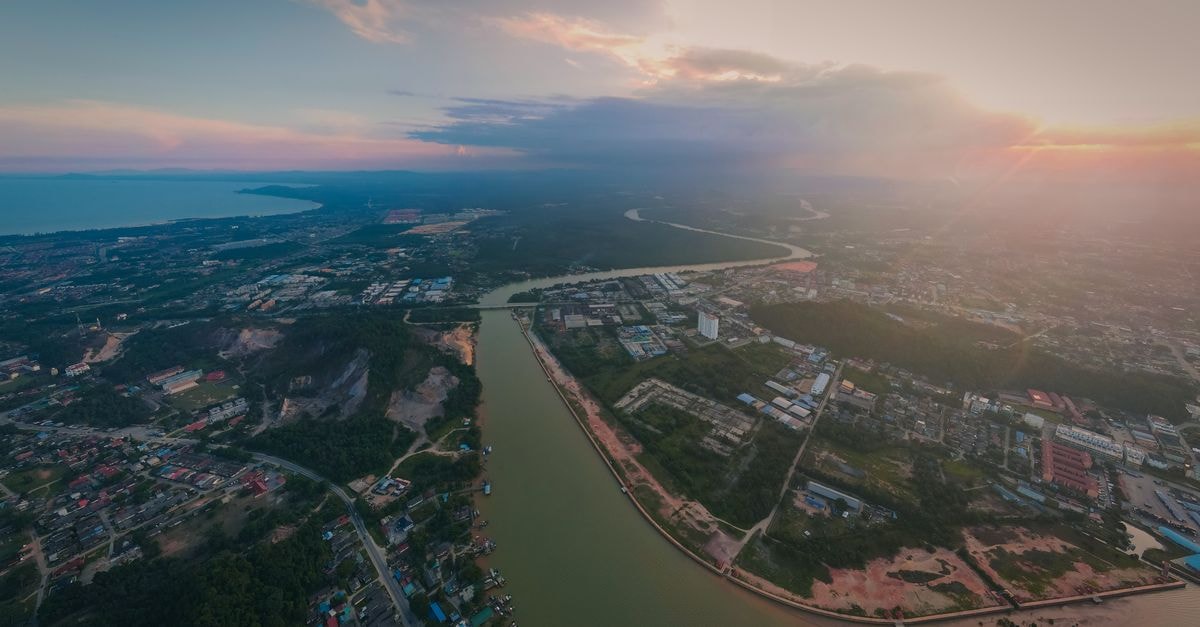 A stunning aerial shot of Chukai, Terengganu capturing the river, town, and coastline at sunset.