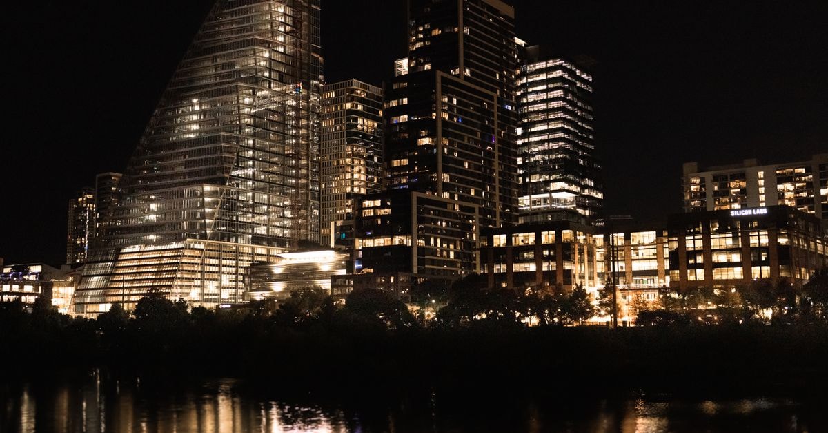 Relais de Kedougou in Kedougou: African-Style Huts by the Gambia River Illuminated skyscrapers reflecting in the river at night in downtown Austin, Texas.
