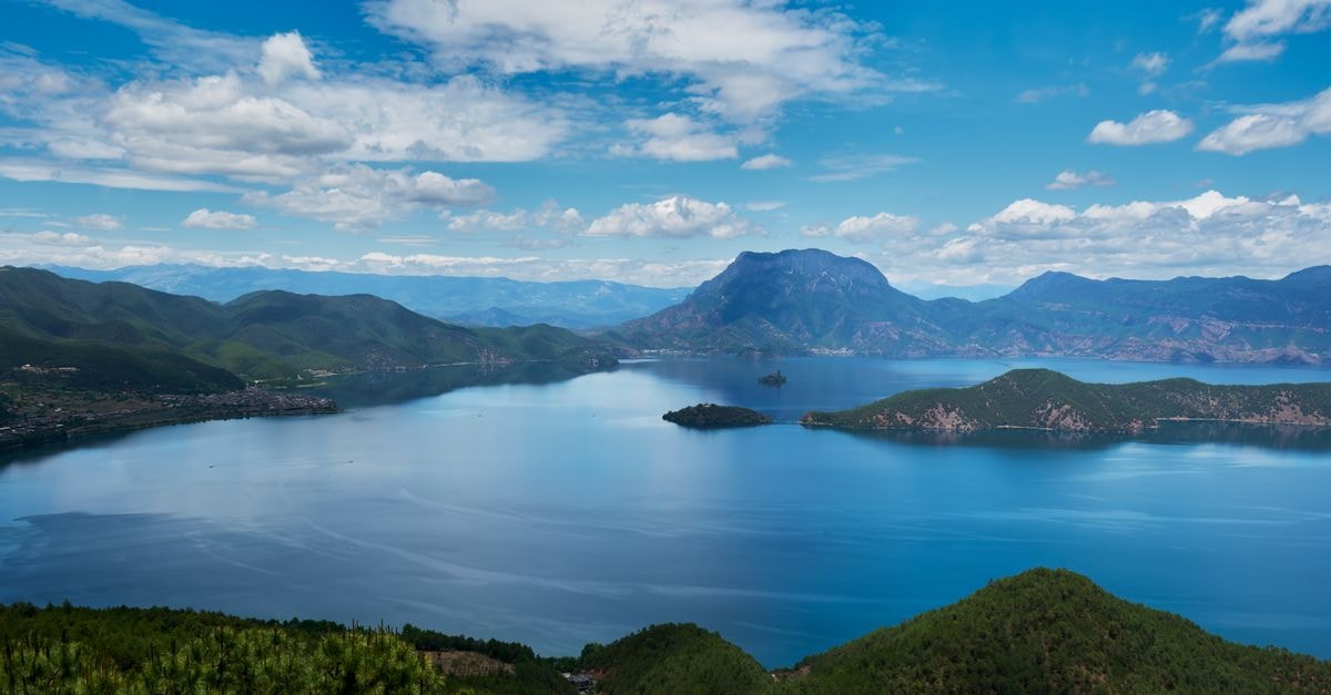 Lincang Travel Guide: An Off-the-Beaten-Path Corner of Yunnan Breathtaking view of Lugu Lake's serene waters surrounded by mountains in Yunnan, China.