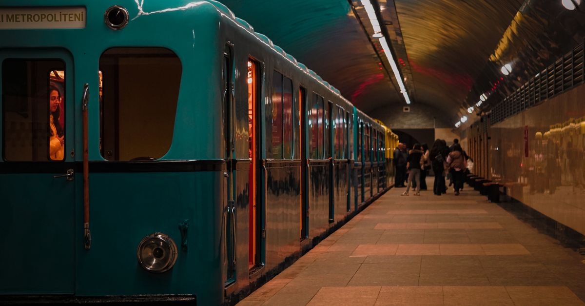 Atmospheric subway station featuring a vintage train and commuters in an urban setting.
