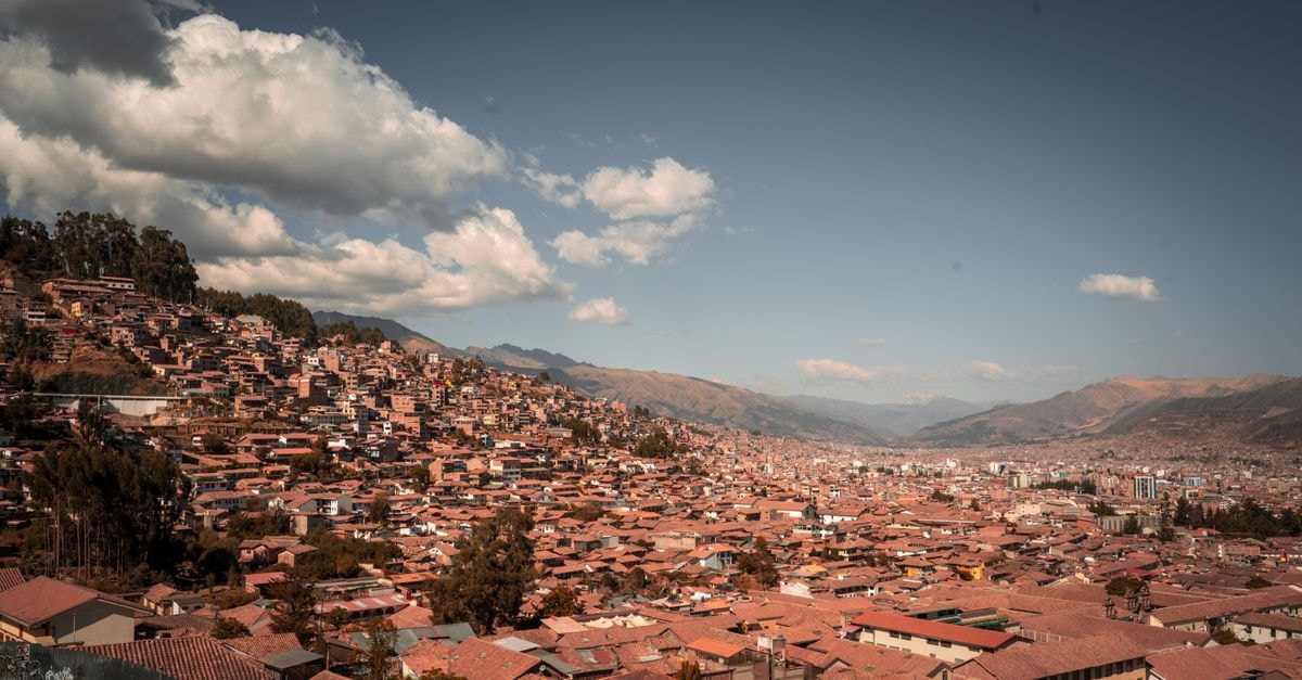Hotel Santa Teresa in Potosí: A Colonial-Style Stay Steps From the Plaza Aerial view of historic Cusco city with mountains and cloudy sky, Peru.