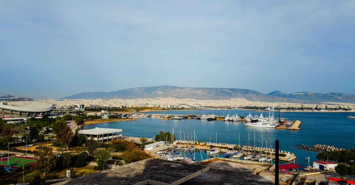 Latakia Travel Guide: A Coastal Lens on Syria's Mediterranean Port A picturesque marina view with yachts, cityscape, and distant mountains under a clear sky.