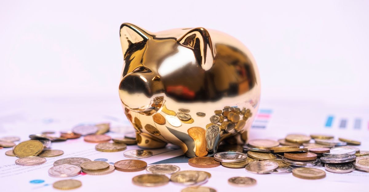 Central Banks' Record Q2 Gold Buying Anchors Demand as Jewellery and ETFs Soften Shiny golden piggy bank on financial documents with scattered coins symbolizes savings.
